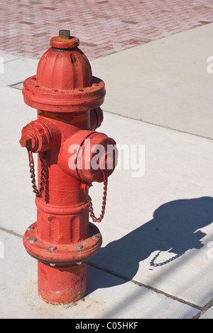 Red Fire Hydrant auf einem Bürgersteig Stadt Stockfoto