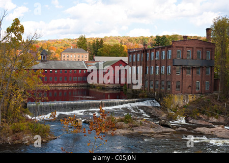 Ein Herbst-Fluss-Szene mit einigen Wasserfällen und alten Mühlengebäuden neben mit bunte Laub am Horizont. Stockfoto