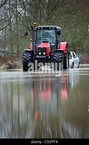 Ein Traktor macht seinen Weg durch Flut Wasser in Essex Stockfoto