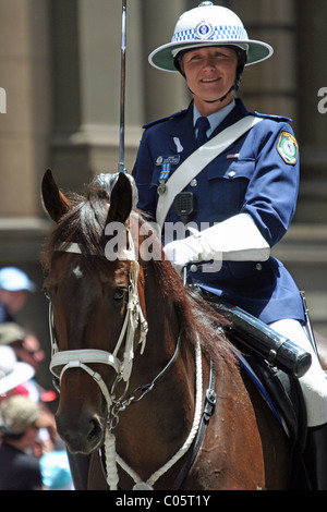 Eine lächelnde Polizistin auf dem Pferderücken, die an der Weihnachtsparade durch die Straßen von Sydney, NSW, Australien teilnimmt Stockfoto