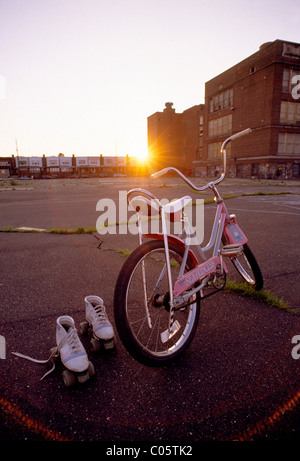 Junge Mädchen Skates und Fahrräder bei Sunet, Hof Schulhof Stockfoto