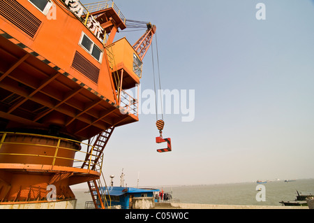 Ein großer Kran heben schwere Last von einem Lastkahn auf dem Yangtze-Fluss in Nanjing. Stockfoto