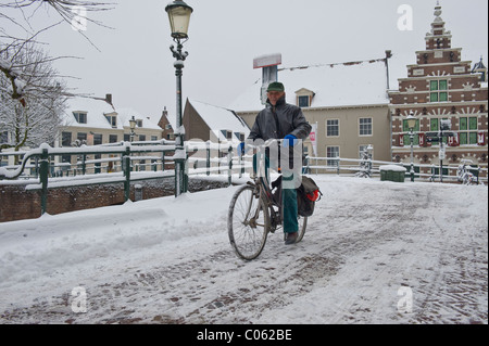 Holländer mit seinem Fahrrad auf einer eisglatten Straße in Amersfoort, Niederlande Stockfoto