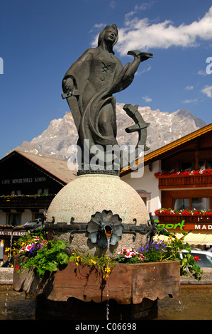 Dorfbrunnen mit einer Statue der Heiligen Katharina vor der Zugspitze massiv, Lermoos, Tirol, Austria, Europe Stockfoto