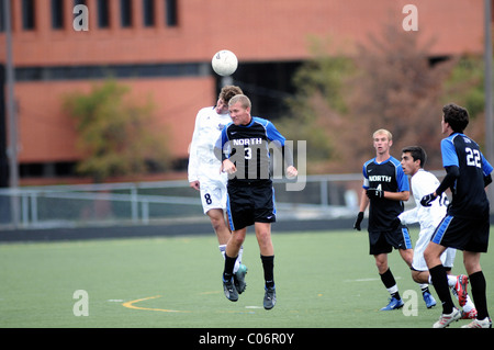 Spieler verwenden Header in einem Versuch, den Besitz der Kugel während einer High School Fußball Match zu gewinnen. USA. Stockfoto