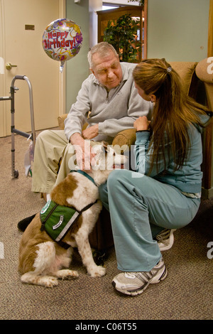Eine Frau Liebe Freiwilligen stellt ein Therapiehund ein Patient in einem Altersheim in Mission Viejo, Kalifornien. Veröffentlichung Stockfoto