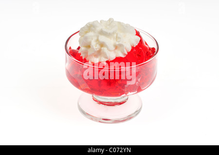 Erdbeere Jell-o mit gepeitschter Creme Belag in Glas Servierplatte auf weißem Hintergrund, isoliert. Stockfoto