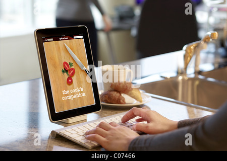 Frau Surfen Kochrezept mit iPad Epicurious Kochen app Stockfoto