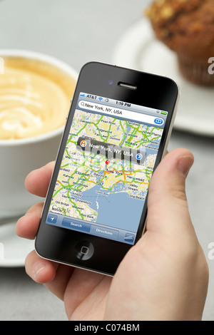 Mann zeigt New York Stadtplan mit Google-Map-Anwendung auf seinem iPhone 4 seinen Kaffee zu genießen Stockfoto