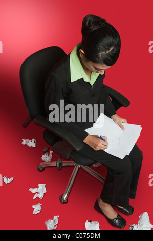 Geschäftsfrau Papierkram zu tun und ist umgeben mit zerknitterten Papiere Stockfoto