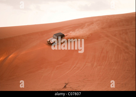 Jeep fahren auf Düne seitwärts, Wahiba Sands, Oman, Naher Osten Stockfoto