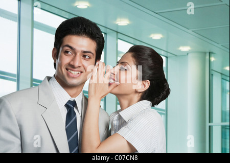 Geschäftsfrau mit einem Geschäftsmann Flüstern Stockfoto