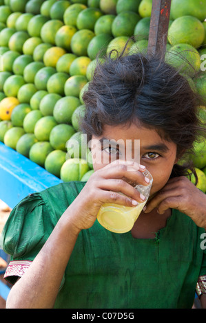 Junge indische Straße Mädchen trinken frischer Orangensaft auf einem indischen Straße, Andhra Pradesh, Indien Stockfoto