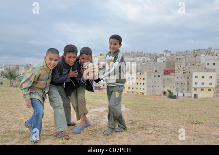 Jungen spielen Fußball, in den hinteren Häusern und Wohnungen in der ärmeren Bevölkerung, Siedlung außerhalb von Fez, Marokko, Afrika Stockfoto