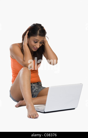 Frau, die vor einem Laptop verwirrt Stockfoto