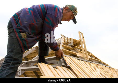 Der Dachdecker stapelt Holz Kachel auf einem Hausdach Stockfoto