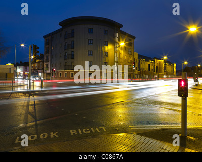 Gebäude an belebten Straßenkreuzung in der Nacht Stockfoto