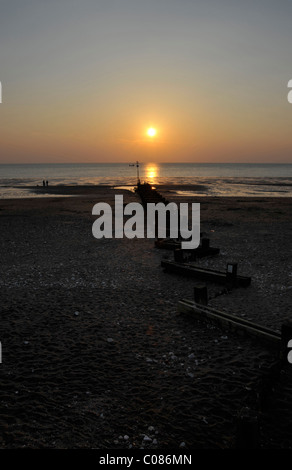 Die untergehende Sonne über den Strand waschen und Hunstanton in Norfolk, England. Stockfoto