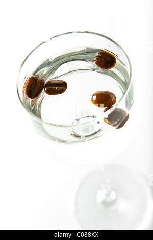 Ein Glas Sambuca mit ganze Kaffee Bohnen einen weißen Hintergrund. Stockfoto