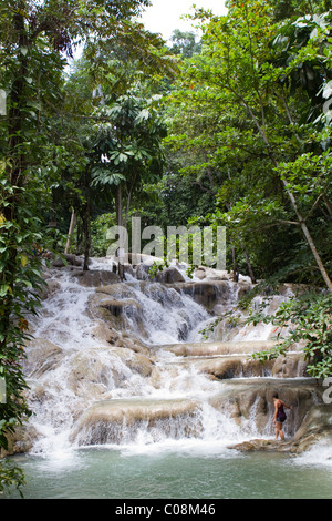 Junge weibliche Touristen beginnt zu Dunns River Falls in Jamaika zu klettern. Stockfoto