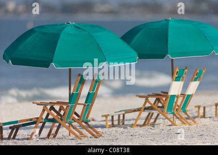 Freie Liegestühle und Sonnenschirme an einem sonnigen Tag am Strand. Stockfoto
