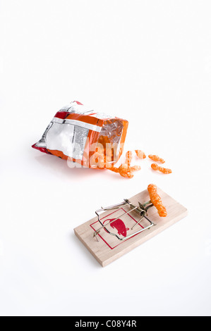 Die Junk-Food-Falle. Eine Tasche von Käse Puffs und eine Mausefalle auf weißem Hintergrund. Stockfoto