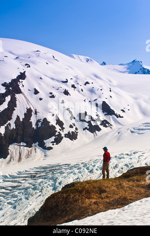 Männliche Wanderer mit Blick auf Exit-Gletscher und das Harding Icefield von einem Felsvorsprung, Kenai Fjords National Park, Kenai-Halbinsel, Alaska Stockfoto