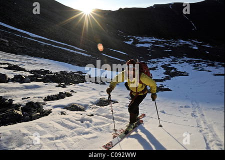 Backcountry Skifahrer macht am frühen Morgen Aufstieg von der Nordseite des Mount Chamberlin, Brooks Range ANWR, Arktis Alaska, Sommer Stockfoto