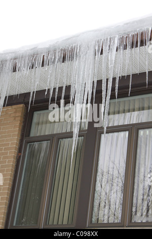 Eiszapfen hängen von Dach Stockfoto