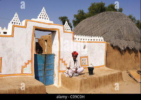 Älterer Mann mit Turban sitzen am Eingang zu seinem Hof, Thar-Wüste, Rajasthan, Indien, Asien Stockfoto