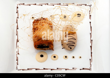 Dessert, Schokoladenkuchen in Kataifi Mantel mit Amaretto-Eis und Zucker Skulptur auf einem weißen Teller, Haute Cuisine Stockfoto