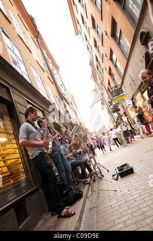 Eine Band spielt auf der Straße mit vielen Menschen herumlaufen Stockfoto