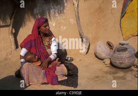 Frau mit einem Baby sitzt vor einem Haus, Thar-Wüste, Rajasthan, Indien, Asien Stockfoto