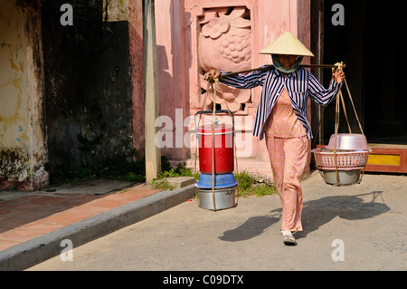 Frau, die Ware gegen die japanische Brücke, Hoi an, Vietnam, Südostasien Stockfoto