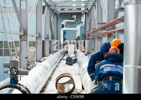 Installation der zentrale Umspannwerk im Werk in Russland. Drei Arbeiter montierten Rohrleitung Stockfoto