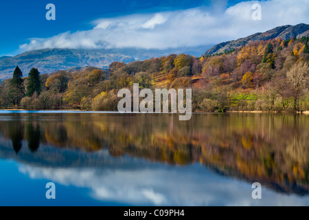 England, Cumbria, Lake District National Park. Lakeland Hügel reflektiert das noch Gesicht des Coniston Water. Stockfoto