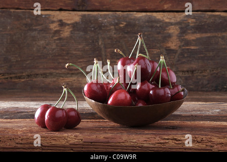 Schale mit Kirschen (Prunus) vor rustikale Holz Stockfoto