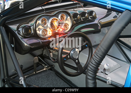 Zifferblätter und Lenkrad auf dem Dashboard Faszie in Cockpit und Kabine eines Rennwagens beleuchtet. Stockfoto