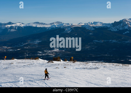 Einzelne Skifahrer mit Blick auf Berg Vista aus auf Piste Skigebiet. Rockey Mountains in Alberta, Kanada. Stockfoto