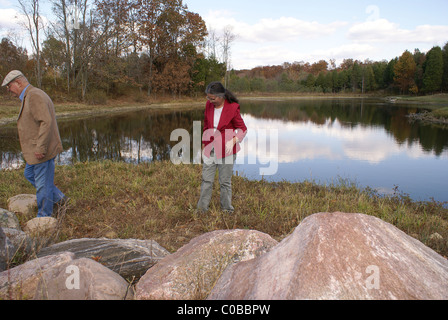 Ältere Paare, die sorgfältig in der Nähe von einem See des Landes. Stockfoto