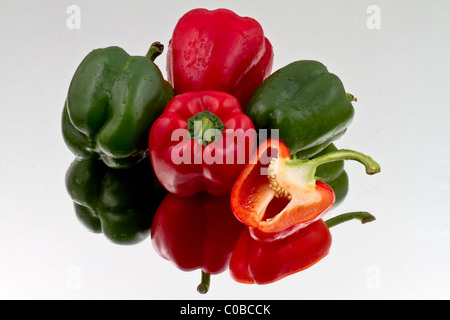 Rote und grüne Paprika und halbierte Paprika auf reflektierende Background Stockfoto