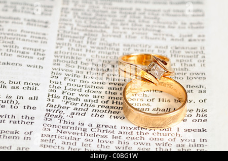 Zwei goldene Hochzeit Ringe ruhen auf den Ehe-Passage aus Epheser 5 in der Bibel Stockfoto