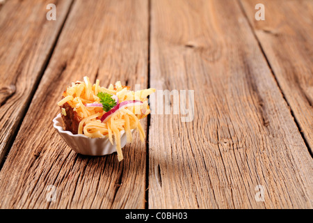 Ofenkartoffel, bestreut mit geriebenem Käse und Zwiebel Stockfoto