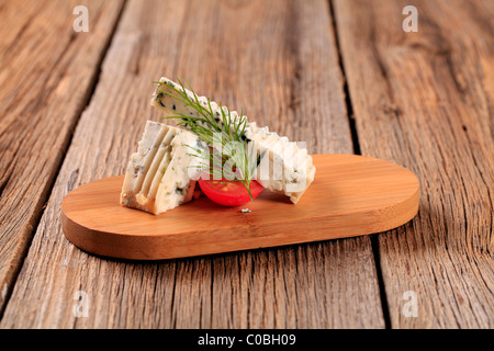 Stücke von Blauschimmelkäse auf ein Schneidebrett Stockfoto