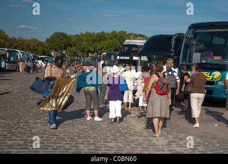 Versailles Frankreich - große Menschenmassen, Touristen, Bus, Parkplatz, African man Hawking Souvenirs, Besuch von 'Chateau de Versailles' Stockfoto