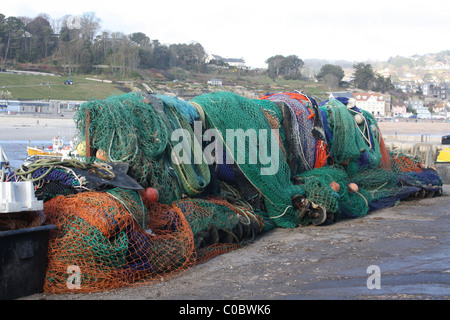 Bunte kommerzielle Fischernetze, die auf dem Cobb, Lyme Regis, gelagert werden. Das bekannte Fischerdorf Dorset, ein geschäftiges Touristenziel an der Jurassic Coast Stockfoto