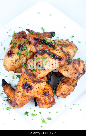 Hähnchenflügel in einer Sauce auf einem weißen Teller gekocht Stockfoto