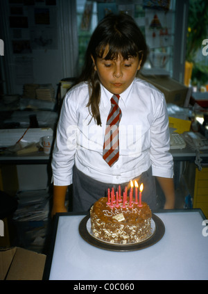 11 Jahre altes Mädchen Ausblasen der Kerzen auf ihrem Geburtstagskuchen Stockfoto