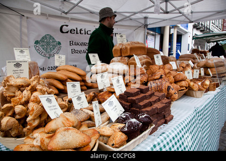 Standinhaber hinter seinem Brot Stall auf einem Bauernmarkt Essen. Stockfoto