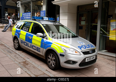 Silber Polizeiauto geparkt vor Geschäften auf einer Straße in Norwich, Norfolk, England. Stockfoto